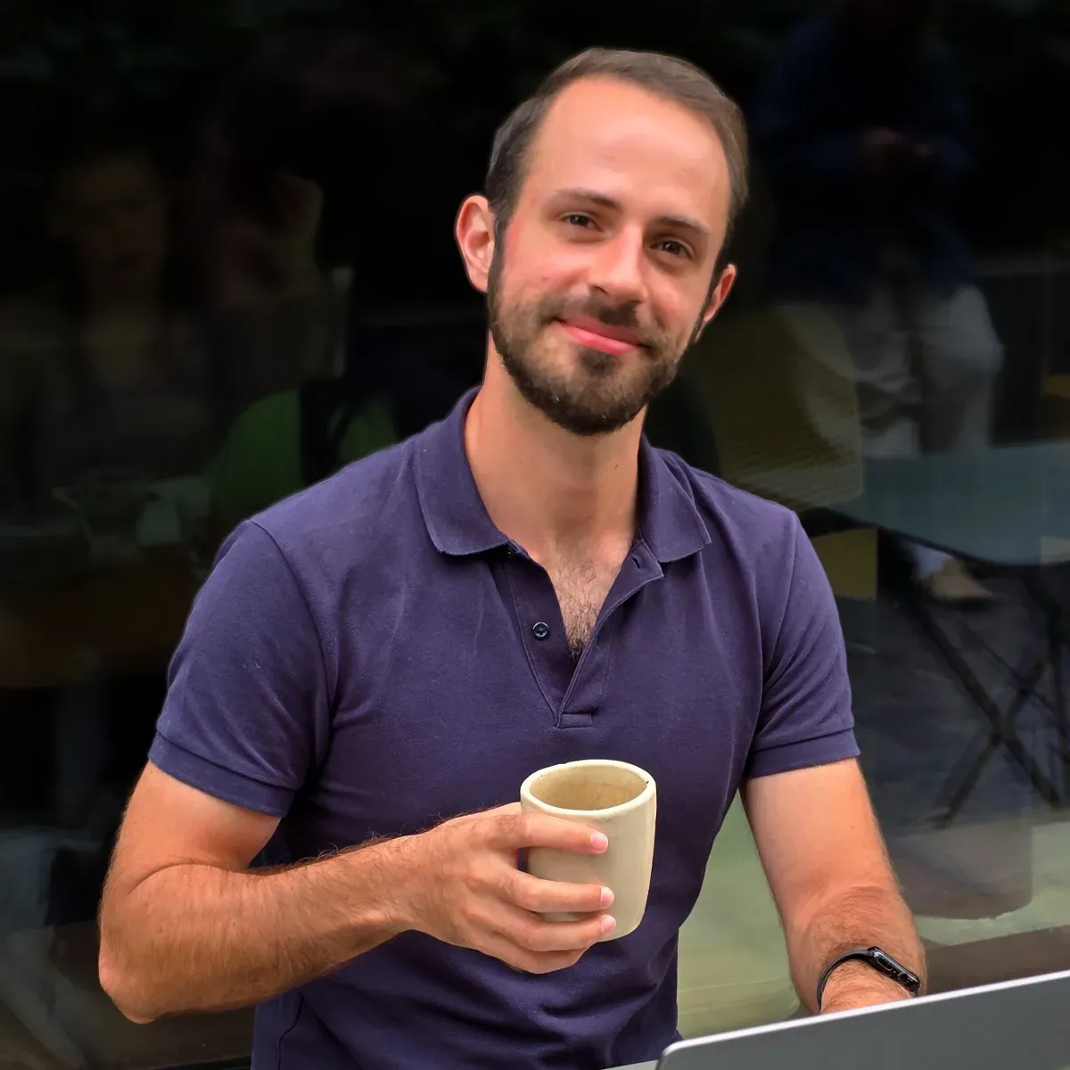 Théo Penavaire in a navy polo, holding a ceramic cup